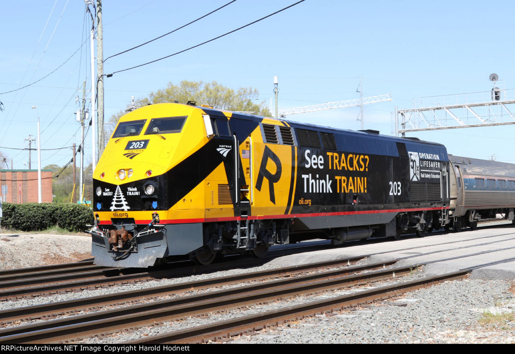 AMTK 203 leads train P080-04 away from the station